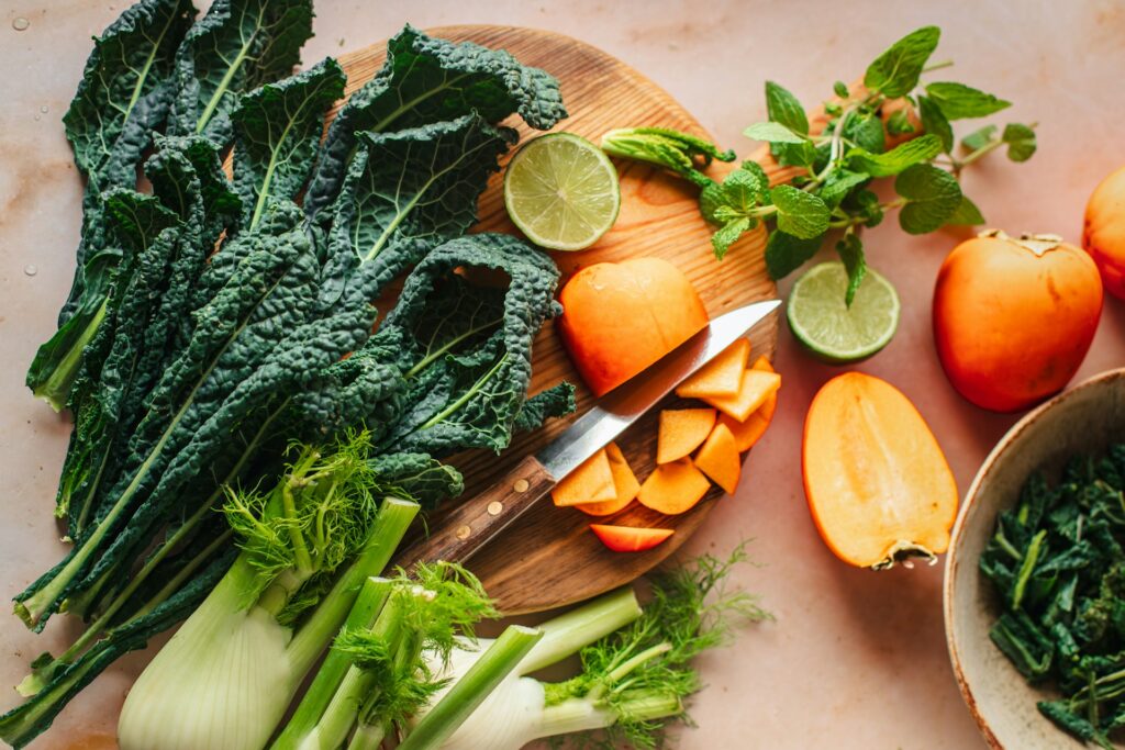 Dark green leafy kale, spinach, and celery on table representing heart-healthy foods.