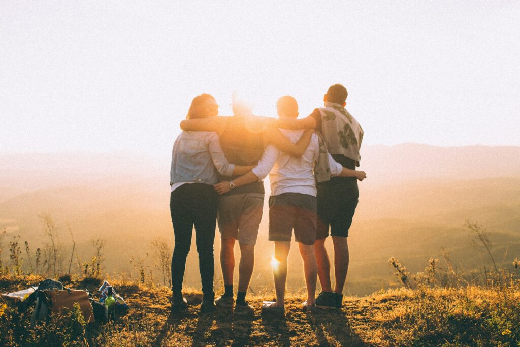 Four friends enjoying time outdoors, symbolizing the importance of social connections in reducing stress and promoting overall well-being.