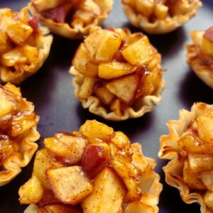 A plate of flaky phyllo cups filled with apple pie filling, ready to serve as a healthy dessert.