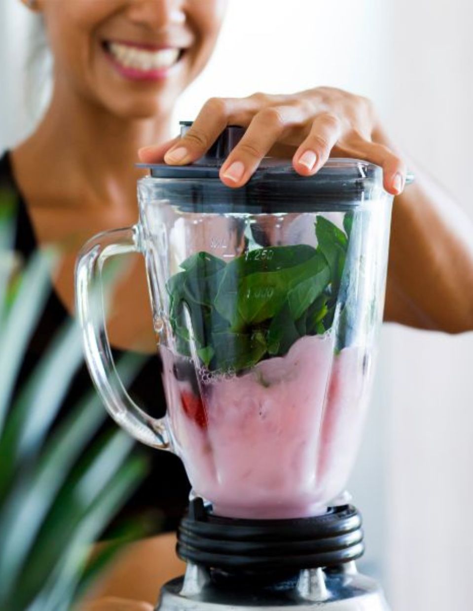 Woman blending a nutritious smoothie with healthy, nourishing ingredients.