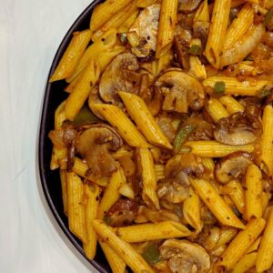 A plate of high-protein Cajun mushroom pasta, a healthy, vegan, and plant-based meal featuring spicy Cajun seasoning, tender Portobello mushrooms, and protein-rich pasta.