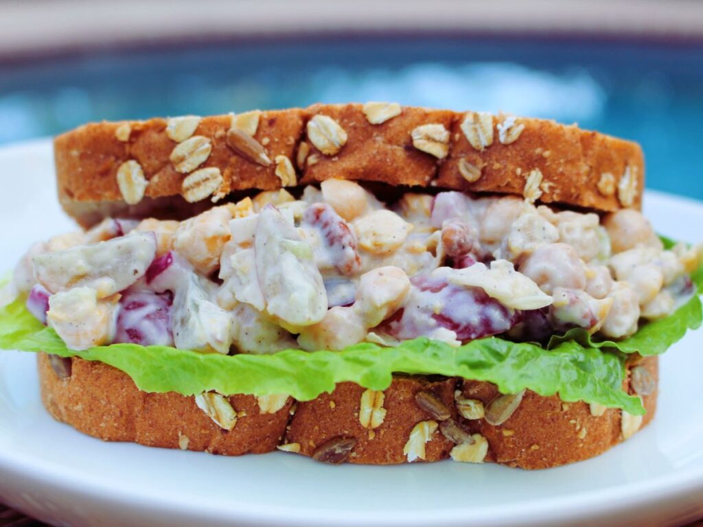 High-fiber chickpea salad sandwich made with creamy chickpeas, red grapes, pecans, and whole-grain bread, a delicious and nutritious option for digestive health.






