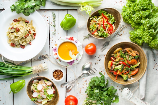 Table filled with colorful plant-based dishes, including salads, soups, and vibrant vegetable platters.