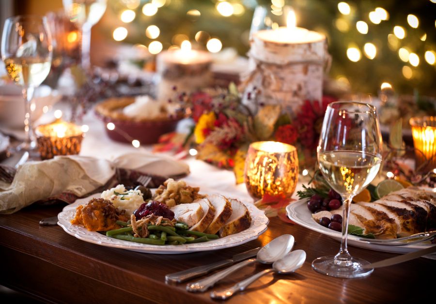 Christmas dinner table with a festive feast of food and drinks, including holiday dishes, desserts, and alcoholic beverages, highlighting mindful eating tips for managing diabetes during the holidays.