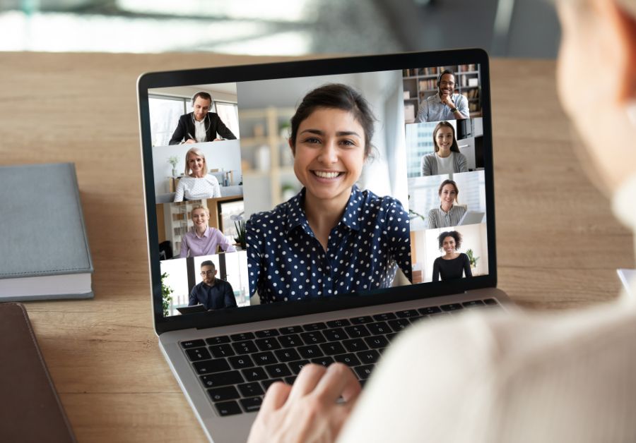 Computer screen displaying multiple faces of participants in an online community support group, engaging in a virtual discussion for shared support and connection