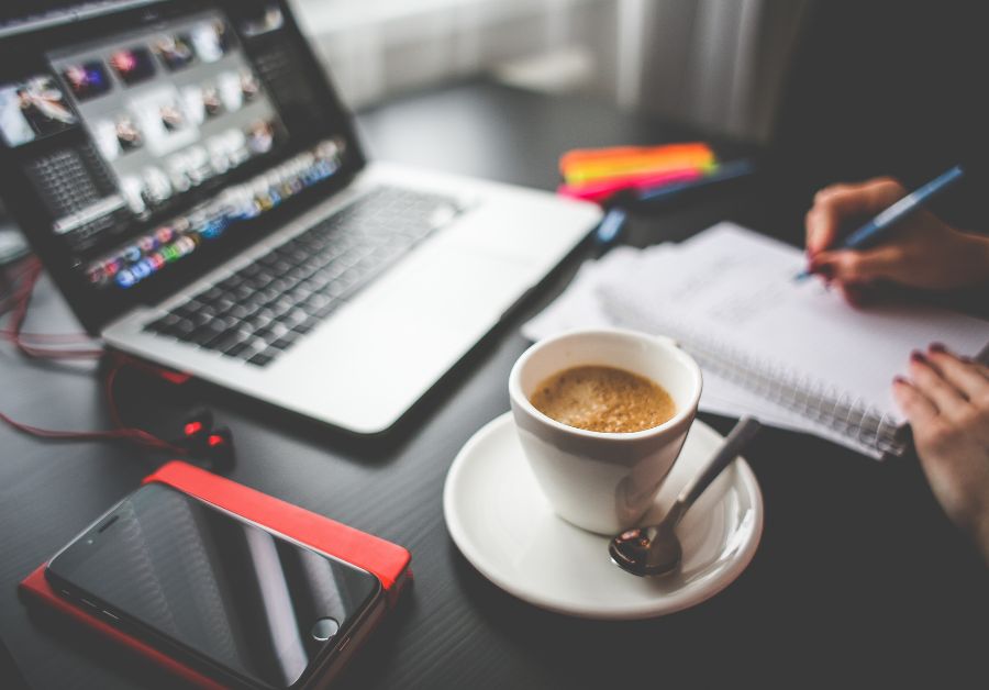 Desk in a corporate wellness setting with a cup of coffee and a computer screen, symbolizing a balanced work environment that supports well-being and productivity.