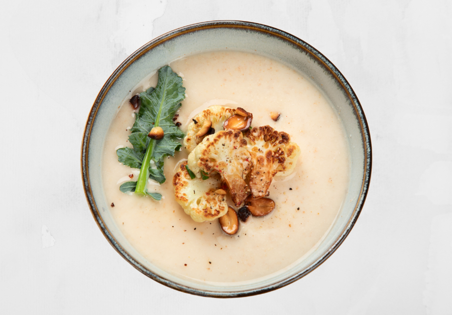 Creamy cauliflower soup, a wholesome dish showcasing the health benefits of cruciferous vegetables, garnished with herbs.