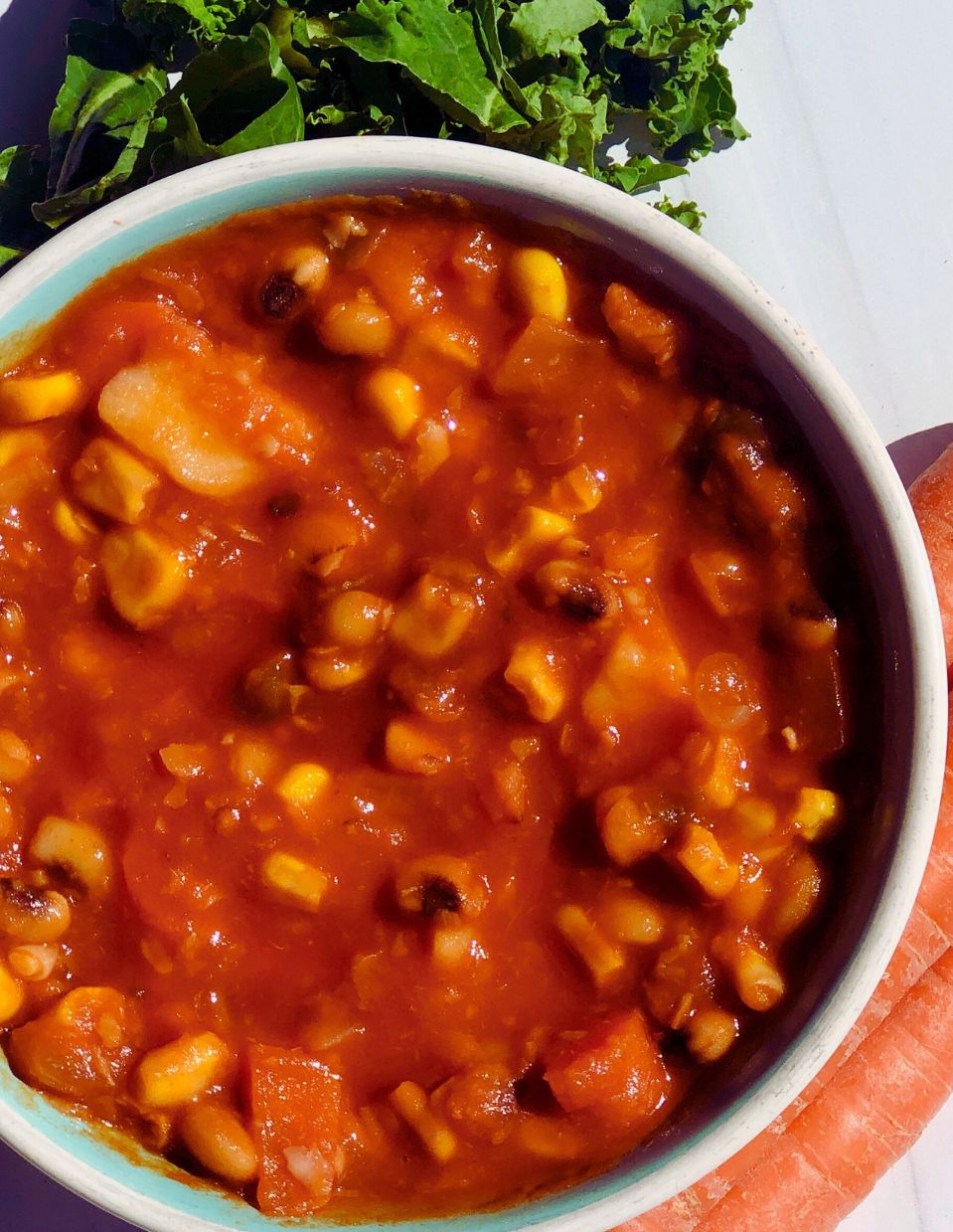 Warm and hearty vegetable soup served in a white bowl, filled with colorful vegetables like carrots, peas, and beans, in a rich tomato-based broth.