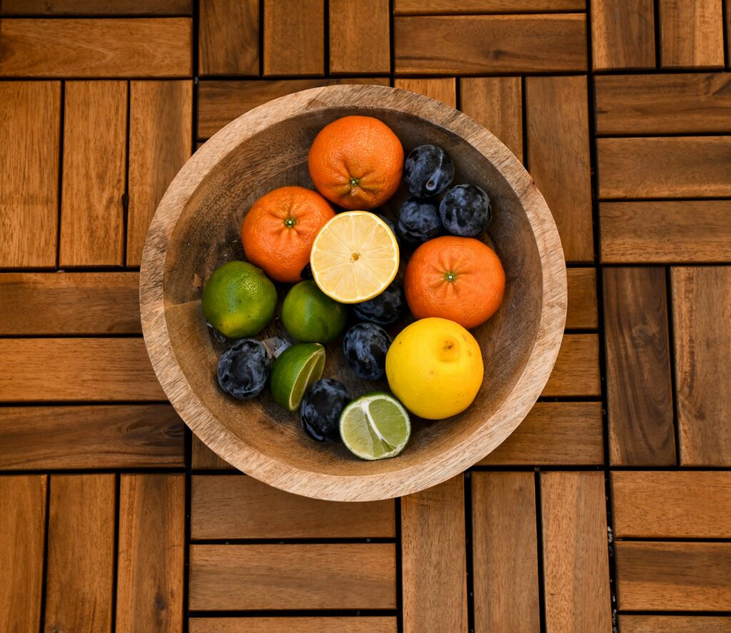 Bowl filled with citrus fruits high in vitamin C, including oranges, lemons, limes, and plums, ideal for boosting immunity and helping keep you from getting sick during cold and flu season.