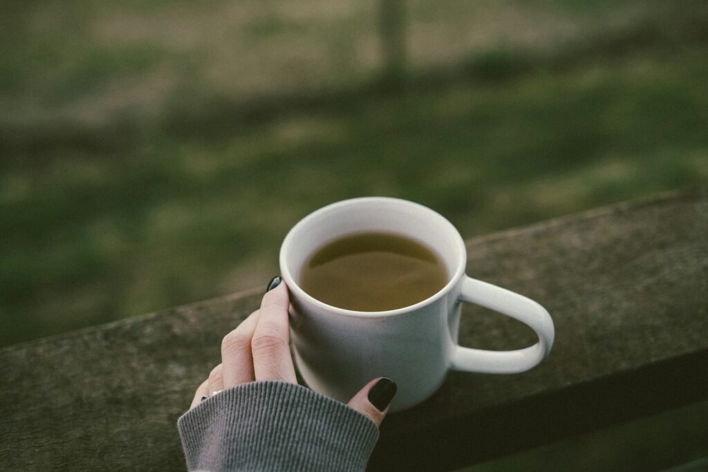 Steaming cup of green tea in a ceramic mug, a soothing beverage rich in antioxidants to boost immunity and promote relaxation."