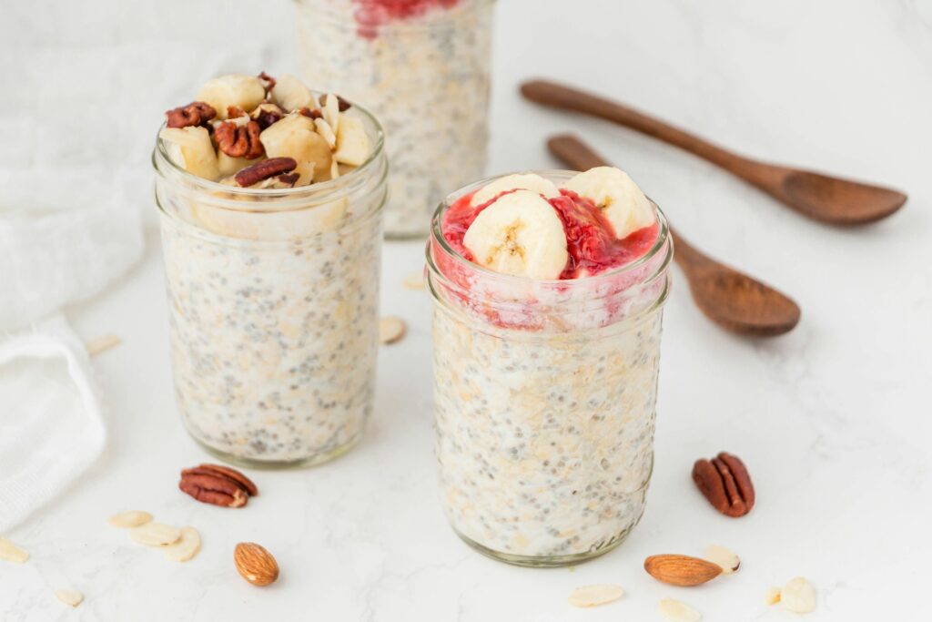 Bowl of creamy yogurt mixed with chia seeds and fresh fruit like apples and bananas, a nutritious combination to support gut health and help keep you from getting sick.

