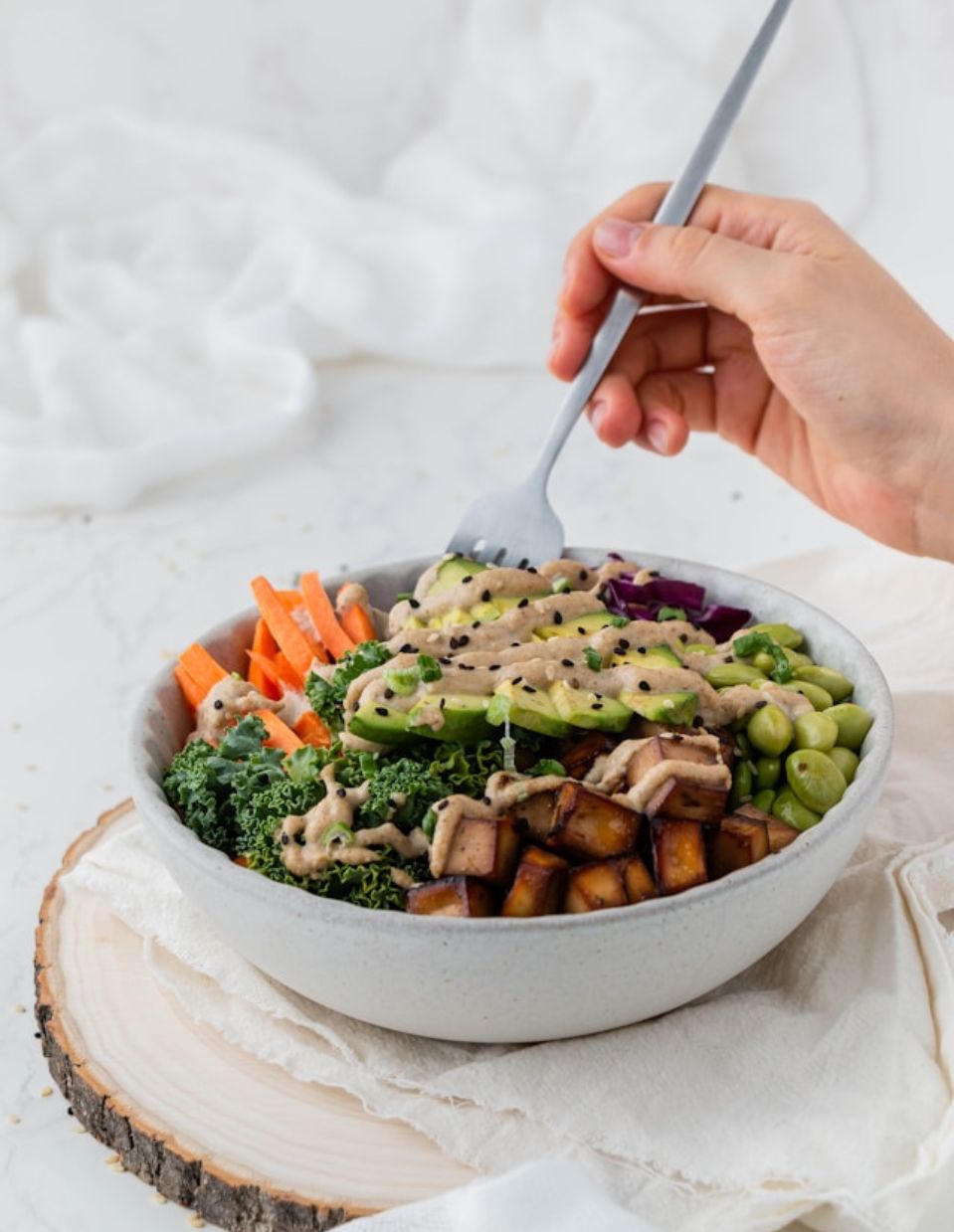 A nourishing plant-based Buddha bowl with tofu, kale, avocado, carrots, edamame, and a creamy dressing, symbolizing a kidney-friendly diet for managing chronic kidney disease (CKD) and slowing disease progression through nutrition.