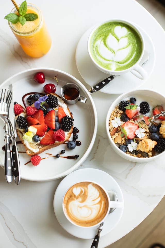 A nutritious breakfast with fruit-topped toast, granola, and lattes, highlighting the benefits of mindful eating and balanced nutrition.