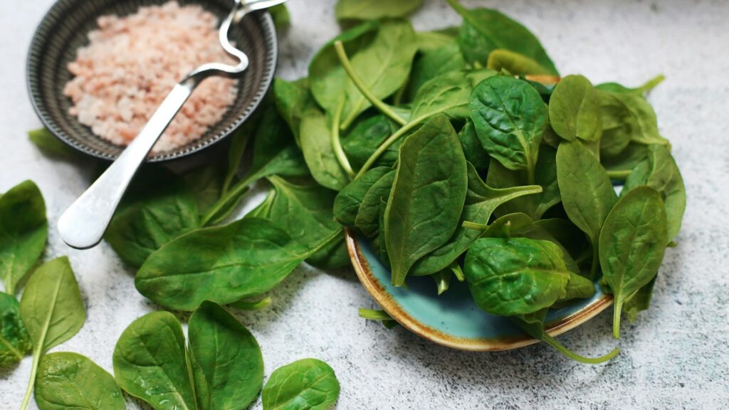 Fresh spinach leaves spread on a  table, showcasing their vibrant green color and heart-healthy nutrients.